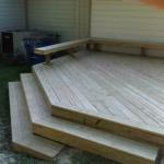 wood deck with decorative wrap around steps and "L" shaped benches