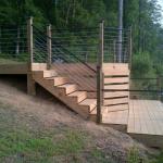 wood deck with cable rails and steps leading down to a fishing deck